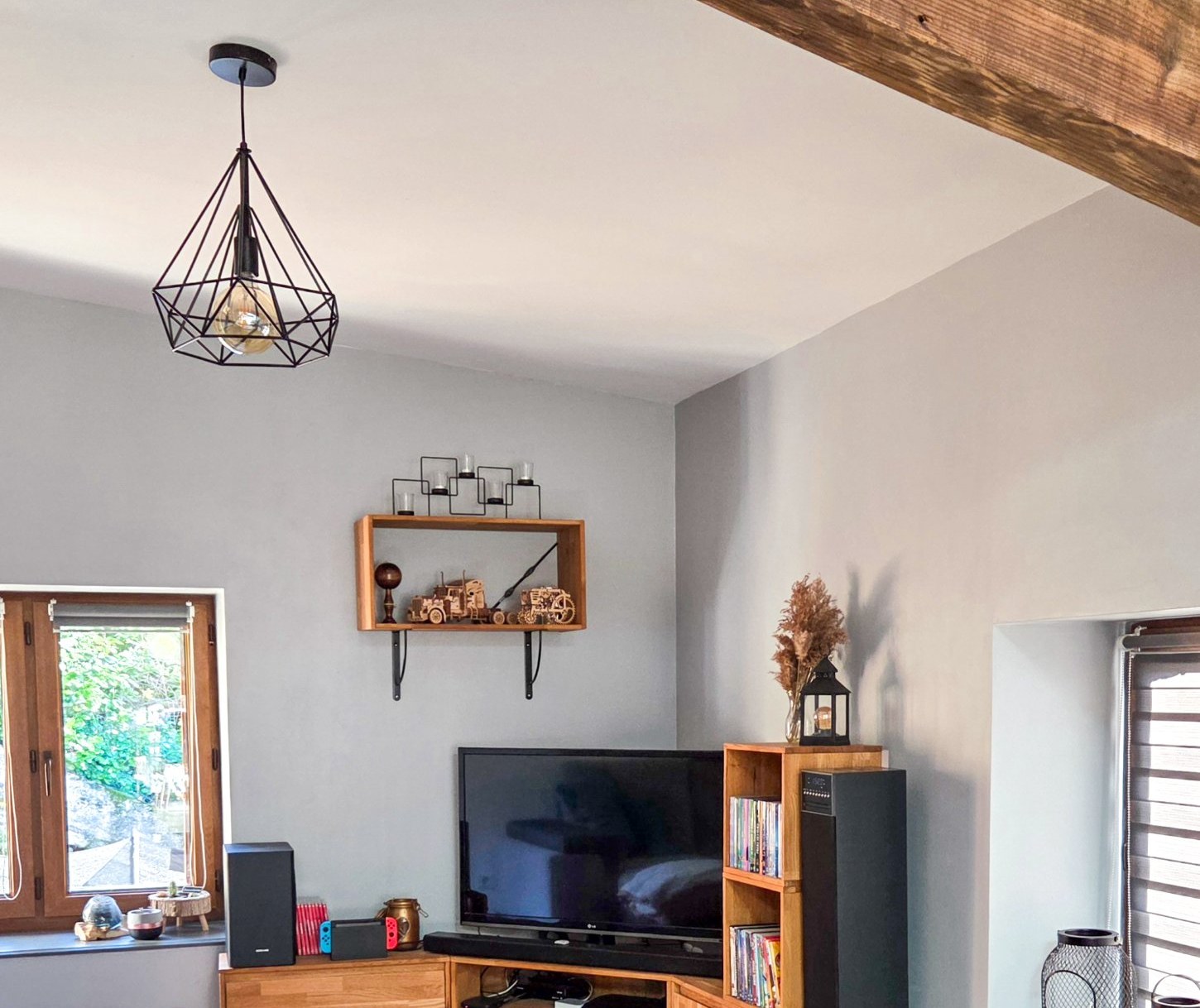 Salon d'une grange rénovée, poutre apparente, parquet chêne et meuble d'angle en bois